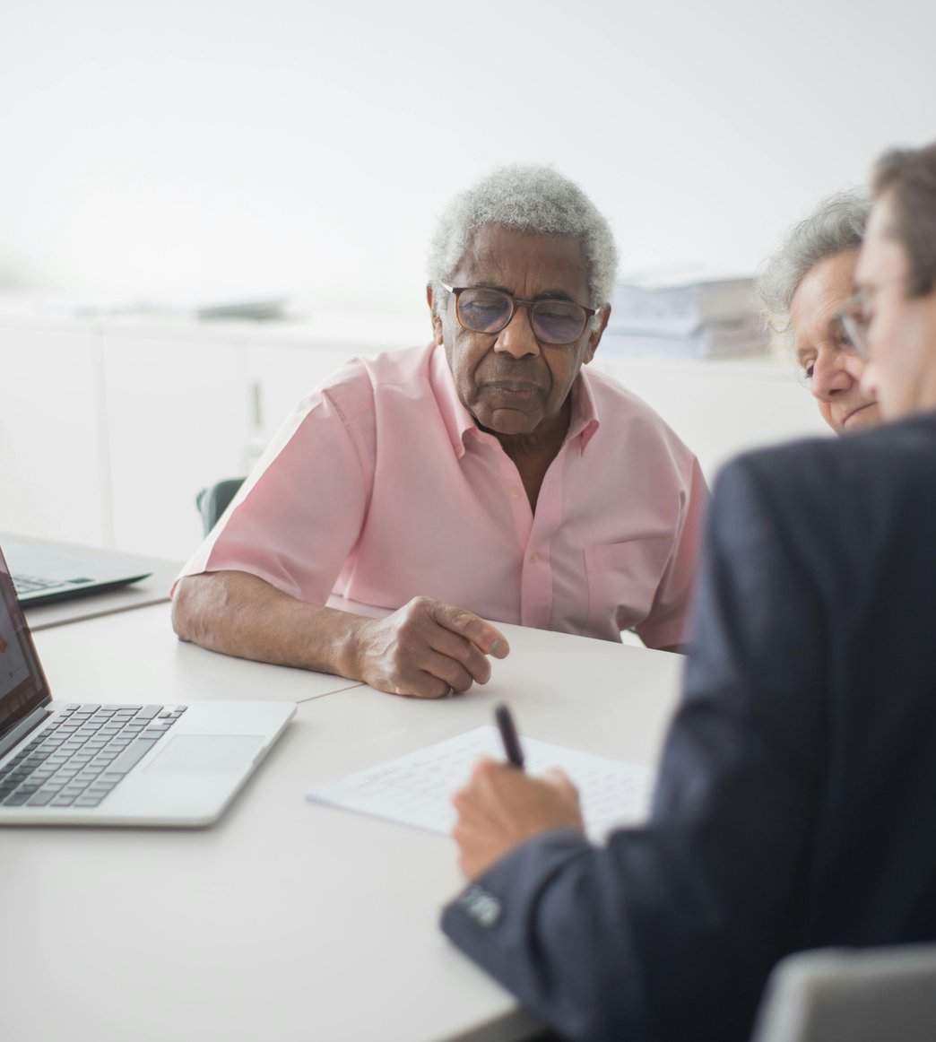 Senior benefits advisor speaking with an elderly couple